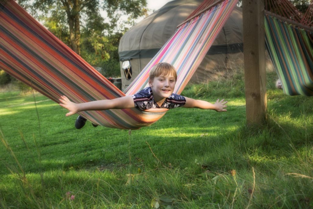 Young boy on a hammock outside the yurt