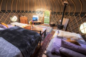Inside one of the yurts with a king size bed, double futons and woodburner