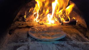 Pizza oven flames cooking a garlic bread