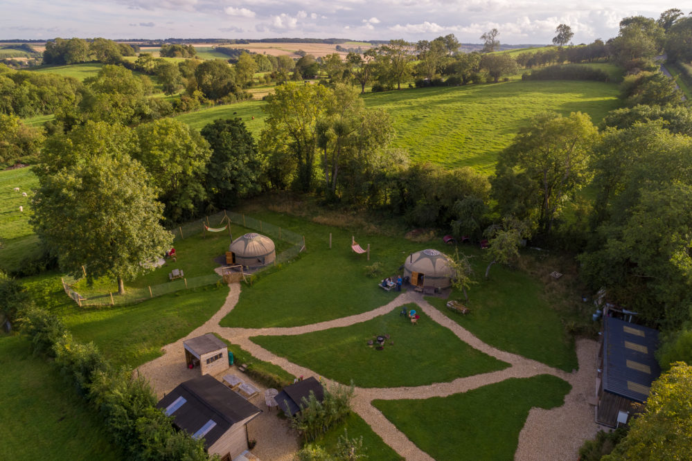 Aerial view of accommodation - 2 yurts and hills behind on family friendly glamping site