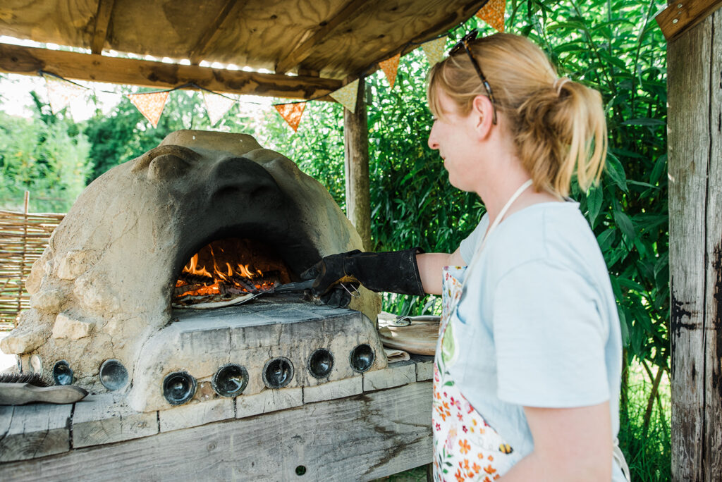 Jane the host cooking pizzas in Bob the Cob Pizza Oven