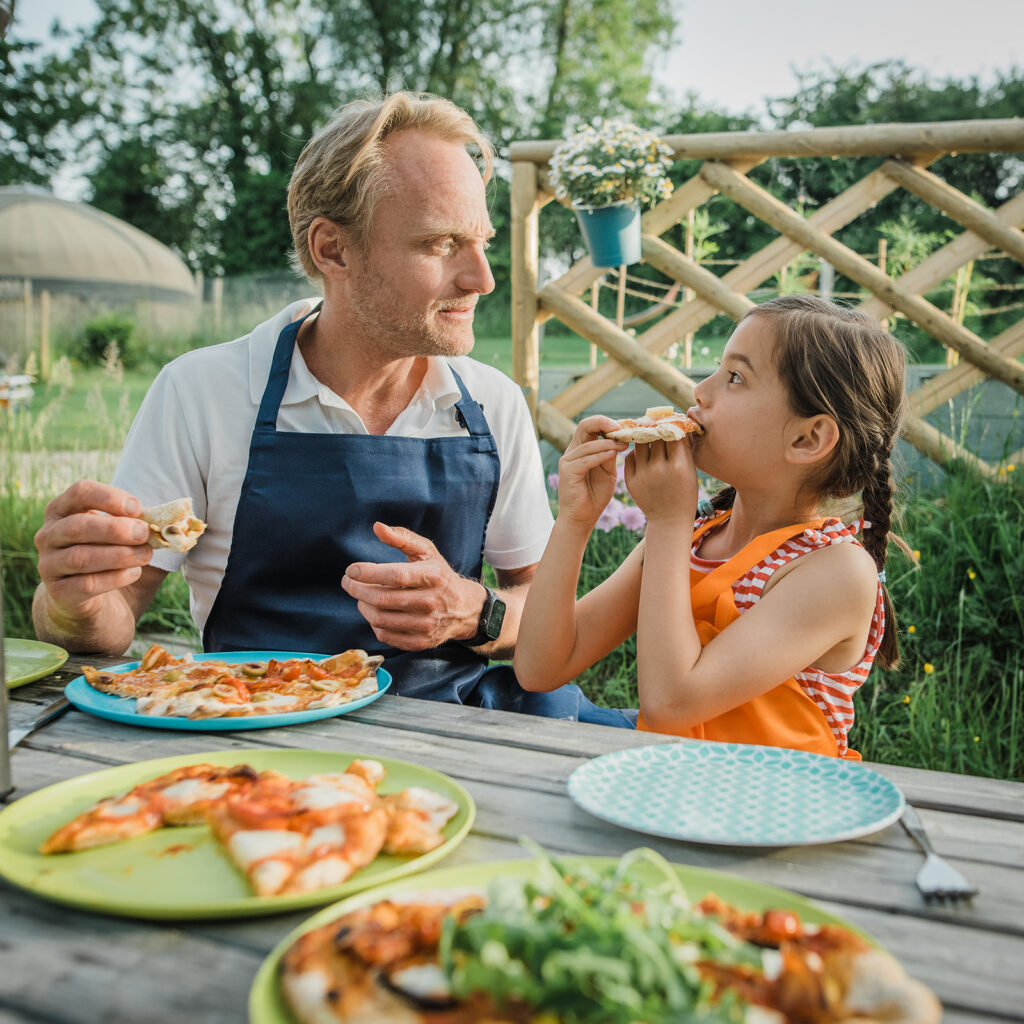 Family friendly glamping with Dad and daughter enjoying pizzas