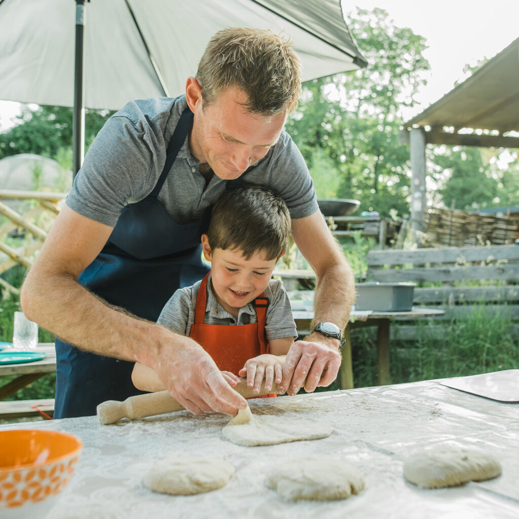 Family Friendly Glamping as father and son roll out pizza dough together