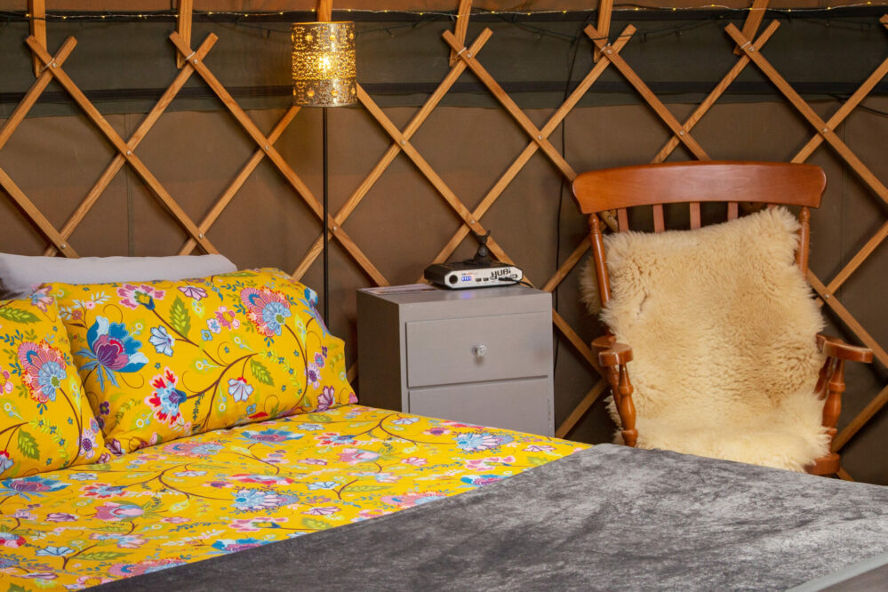 Interior yurt photo: Glamping in style - main bed and chair with sheepskin in the yurt